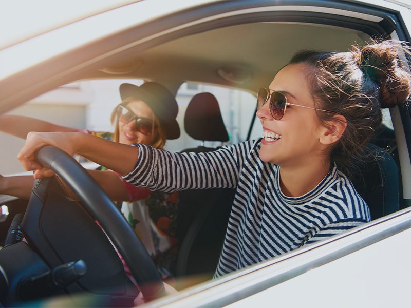 Veninder kører bil og er glade