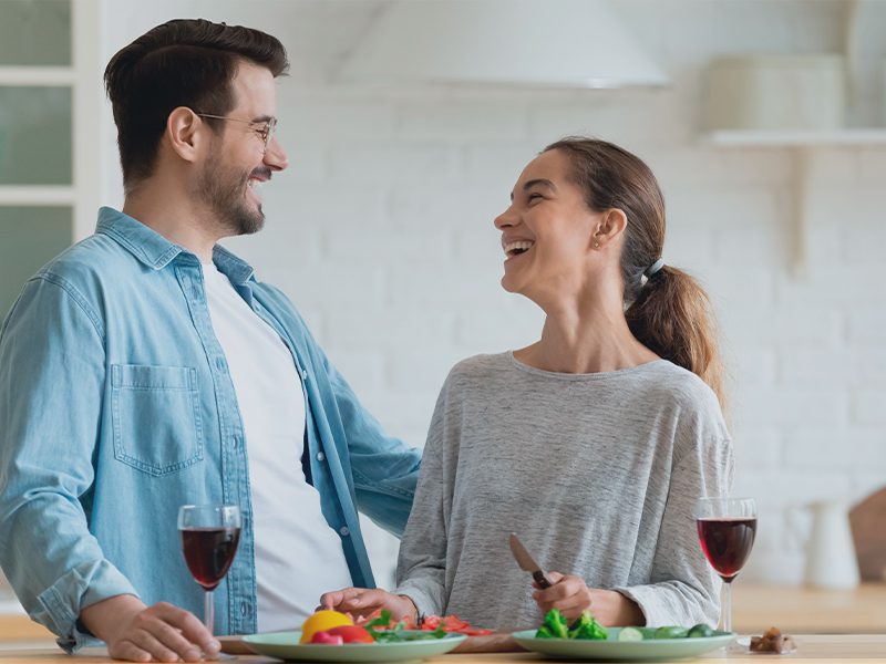 Mand og kvinde i køkken og griner