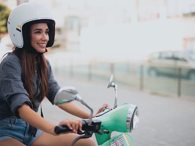 Kvinde på scooter med hjelm