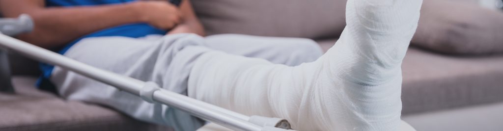 Mand med brækket ben i sofa