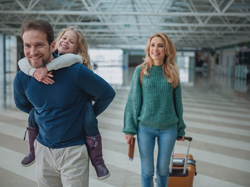 Familie med kuffert i lufthavn