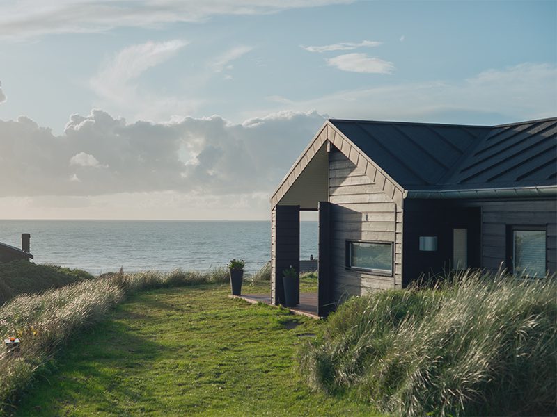 Sommerhus ved vandet i grønne omgivelser