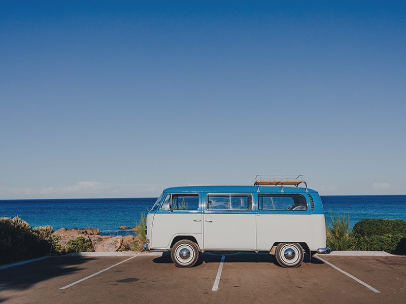 Veteranbil parkeret ved havet på parkeringsplads