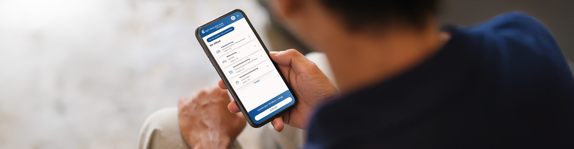 Mand med telefon i hånden med illustration af det faglige hus forsikringtjek