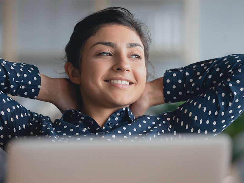 Kvinde sidder afslappet på sofaen